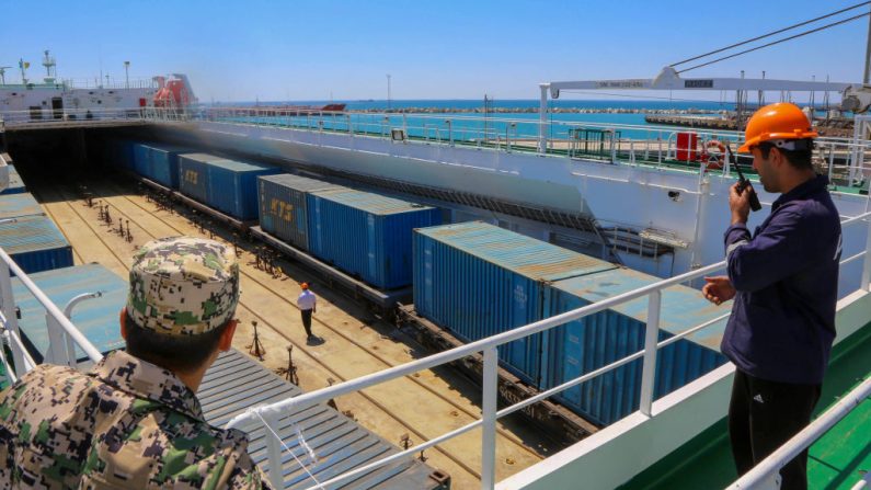 Des hommes travaillent dans le port maritime d'Aktau, au Kazakhstan, le 15 août 2018. (TALANT KUSAIN/AFP via Getty Images)