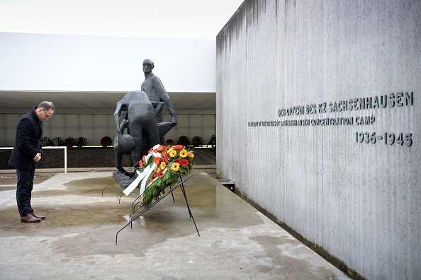 L'ancien ministre allemand des Affaires étrangères, Heiko Maas, dépose une gerbe devant une sculpture de l'Allemand Waldemar Grzimek sur le site commémoratif de la « Station Z » de l'ancien camp de concentration de Sachsenhausen pour commémorer l'anniversaire de la libération du camp en avril 1945, à Oranienburg, au nord de Berlin, le 18 avril 2021. (SOEREN STACHE/POOL/AFP via Getty Image).