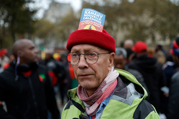 Un manifestant porte une pancarte « Indépendance de la Nouvelle-Calédonie Kanaky, soutenons le combat du peuple kanak ! » alors qu'il participe à une marche contre la vie chère à Paris. (GEOFFROY VAN DER HASSELT/AFP via Getty Images)