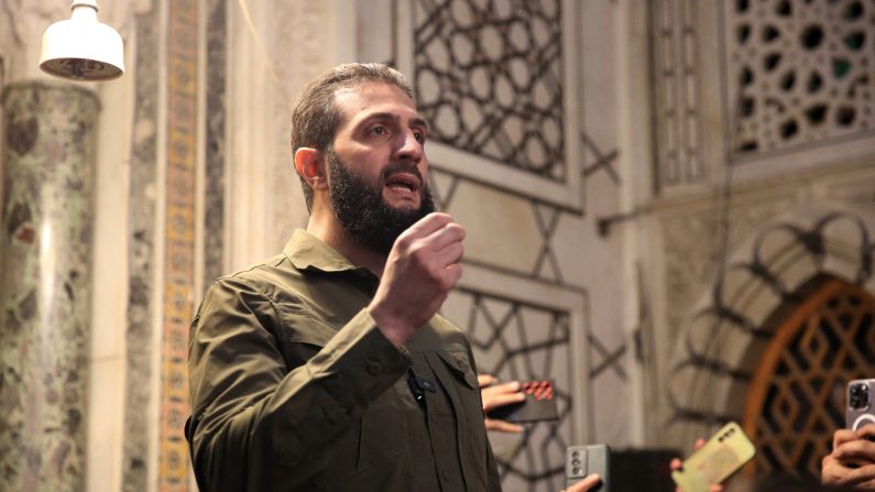 Le chef du groupe islamiste syrien Hayat Tahrir al-Sham (HTS), qui a dirigé une offensive rebelle éclair arrachant Damas au contrôle du gouvernement, Abu Mohammed al-Joulani, s'adresse à la foule dans la célèbre mosquée des Omeyyades de la capitale, le 8 décembre 2024. (AREF TAMMAWI/AFP via Getty Images)