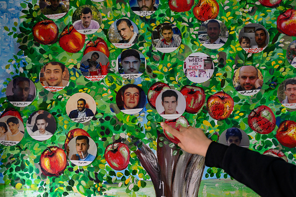 Une fresque représentant des photographies de personnes disparues en Syrie est accrochée au mur de l'association des détenus et des personnes disparues de la prison de Saydnaya (ADMSP), à Gaziantep, le 11 décembre 2024.   (YASIN AKGUL/AFP via Getty Images)