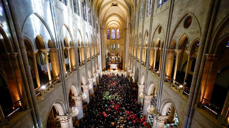 Des participants, dont des ouvriers de la reconstruction de Notre-Dame de Paris, se sont rassemblés lors d'un discours du président français Emmanuel Macron (au c.) dans la nef de la cathédrale à Paris, le 29 novembre 2024. (SARAH MEYSSONNIER/POOL/AFP via Getty Images)