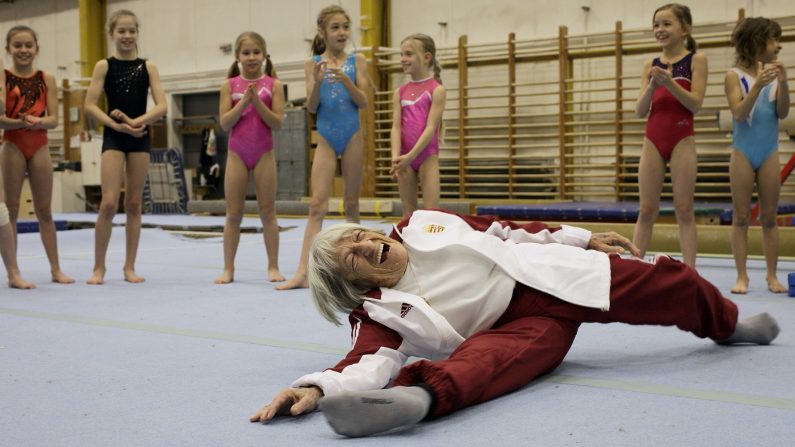 La plus ancienne championne olympique, la Hongroise Agnes Keleti, âgée de 95 ans, fait une fente devant de jeunes gymnastes hongroises dans un centre d'entraînement local de Budapest, le 16 janvier 2016. (PETER KOHALMI/AFP via Getty Images)